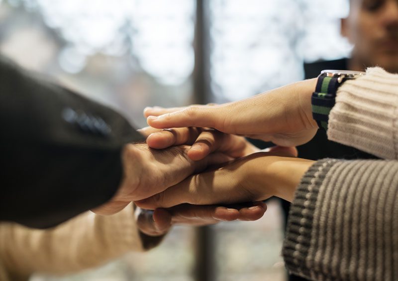 stacking hands together - mission and values